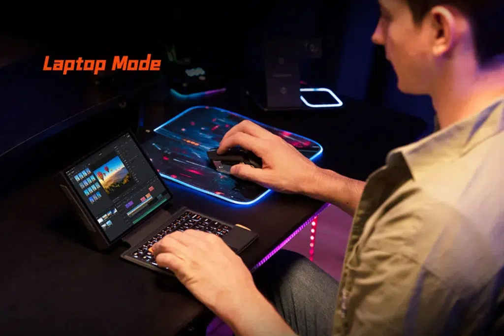 The ONEXPLAYER X1 Mini used as a compact laptop setup with a keyboard and mouse, running video editing software, highlighting its versatility for creative and productivity tasks.